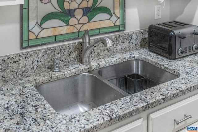 details with a sink, light stone countertops, tasteful backsplash, and a toaster