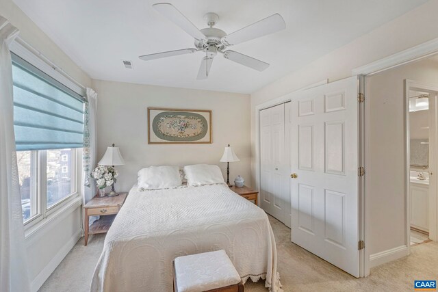 bedroom with light carpet, a closet, baseboards, and multiple windows