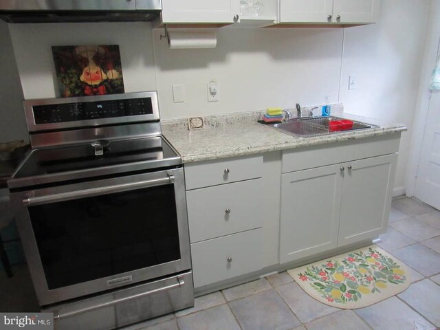 831 Good Mill Rd, Rileyville, VA 22650 - kitchen with stainless steel electric range oven, a sink, light tile patterned floors, white cabinetry, and light stone countertops