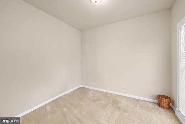 spare room featuring carpet flooring and baseboards
