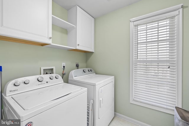 washroom with cabinet space, separate washer and dryer, and baseboards