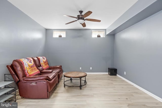 sitting room with light wood finished floors, plenty of natural light, a ceiling fan, and baseboards