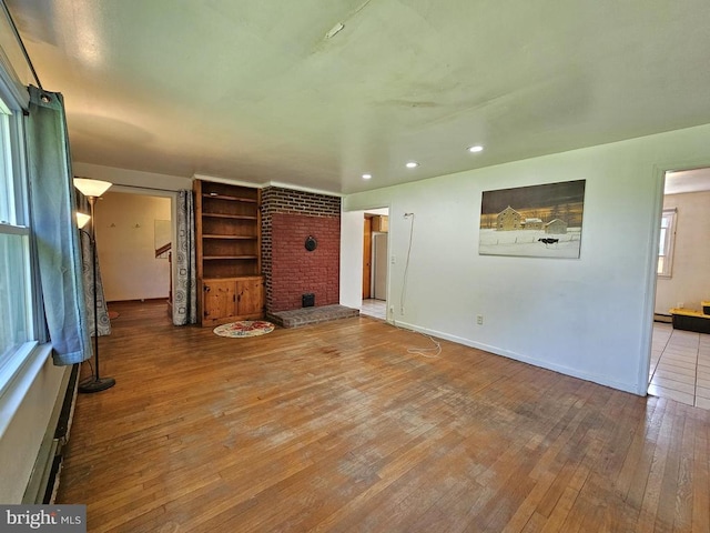 1846 Repton Mill Rd, Aroda, VA 22709 - unfurnished living room featuring wood-type flooring, recessed lighting, and a brick fireplace