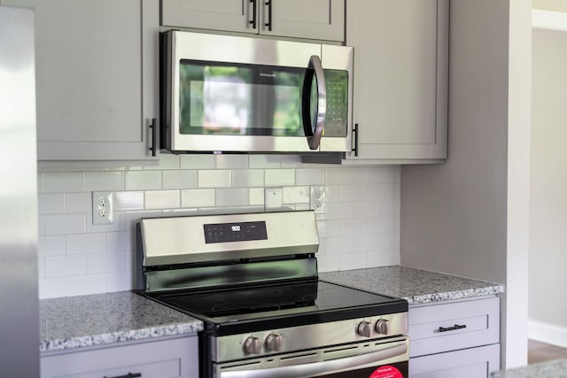 91 Cooper Dr, Stuarts Draft, VA 24477 - kitchen with stainless steel appliances, gray cabinets, decorative backsplash, and light stone countertops