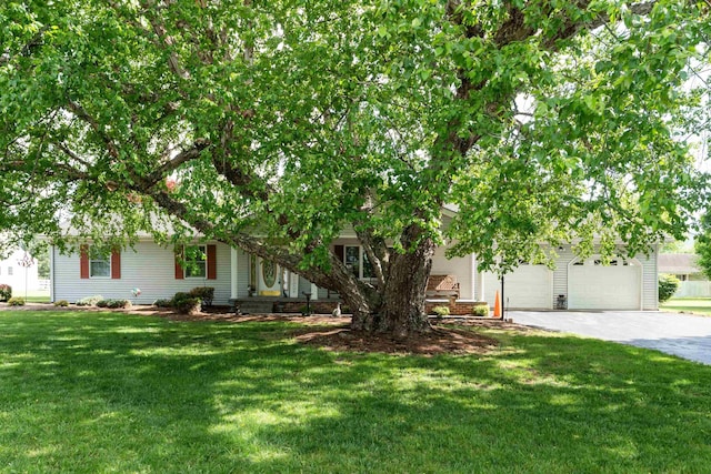 obstructed view of property featuring driveway, a garage, and a front lawn