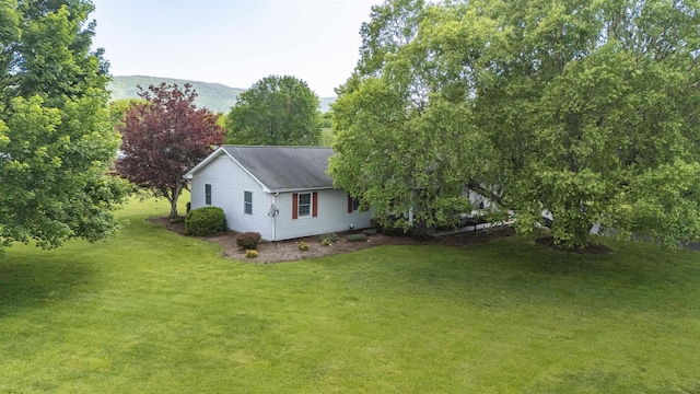 view of home's exterior featuring roof with shingles and a lawn