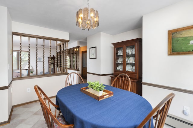 dining room with a chandelier, a baseboard heating unit, and baseboards
