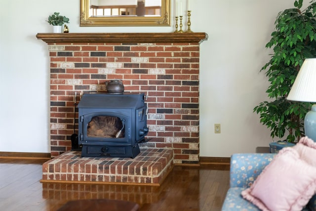 detailed view of baseboards, wood finished floors, and a wood stove
