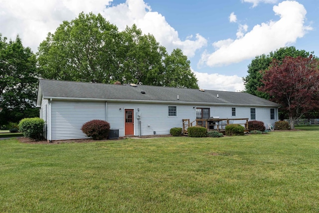 rear view of property with a lawn and a wooden deck