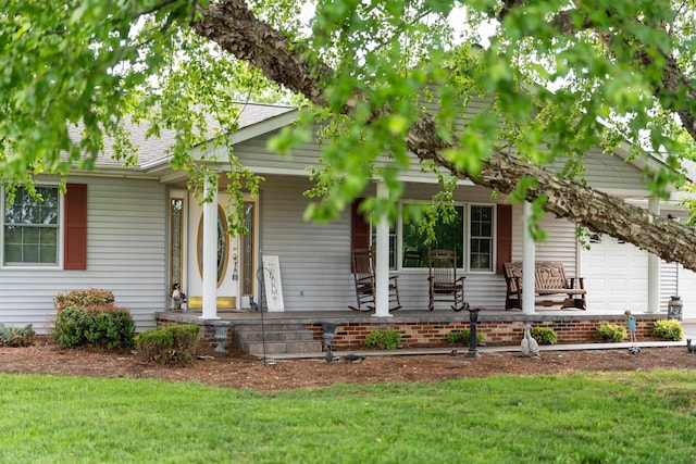 view of front of home with covered porch, a garage, and a front yard