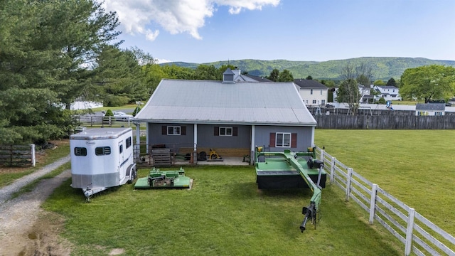 rear view of property featuring a mountain view, a patio area, and metal roof