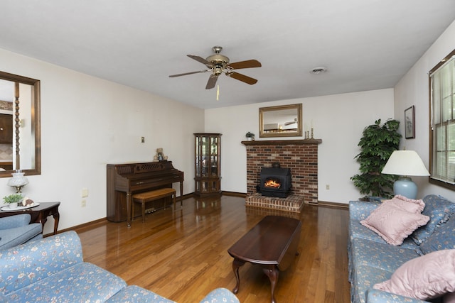 living area with wood finished floors, ceiling fan, baseboards, and a fireplace