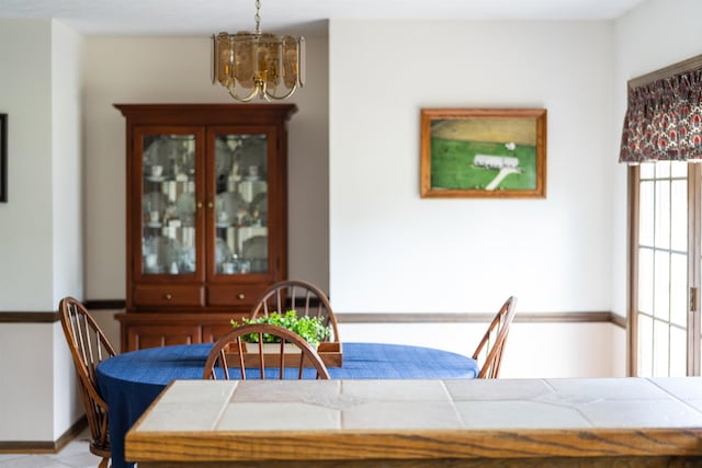 dining space with a chandelier and baseboards