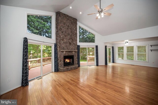 614 Yorktown Blvd, Locust Grove, VA 22508 - unfurnished living room featuring high vaulted ceiling, wood finished floors, ceiling fan, a stone fireplace, and baseboards