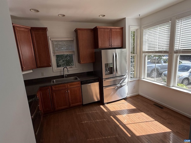 115 Melbourne Prk Cir Unit D, Charlottesville, VA 22901 - kitchen featuring stainless steel appliances, dark countertops, dark wood-style flooring, recessed lighting, and brown cabinetry
