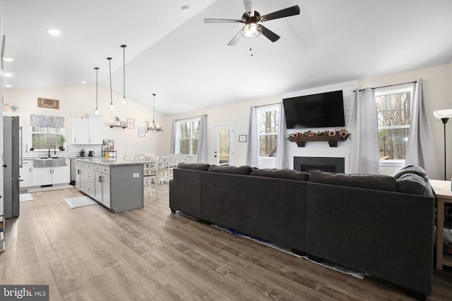 5223 Wyndemere Cir, Mineral, VA 23117 - living area with a large fireplace, a wealth of natural light, vaulted ceiling, and ceiling fan with notable chandelier