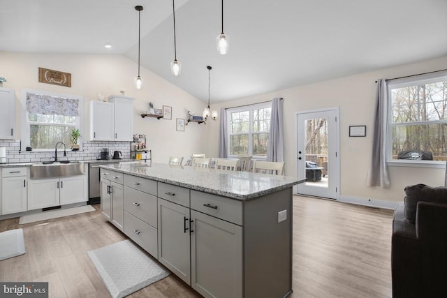 5223 Wyndemere Cir, Mineral, VA 23117 - kitchen with a sink, lofted ceiling, decorative backsplash, a kitchen island, and light wood-style floors
