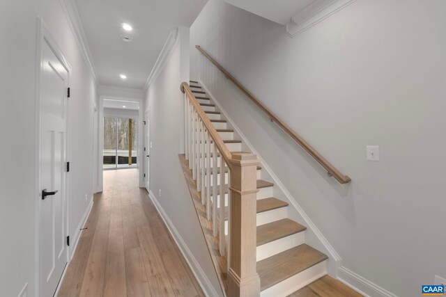 staircase with hardwood / wood-style floors, baseboards, ornamental molding, and recessed lighting