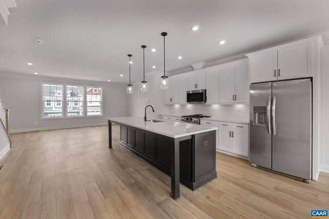 kitchen with stainless steel appliances, a sink, light countertops, crown molding, and white cabinetry