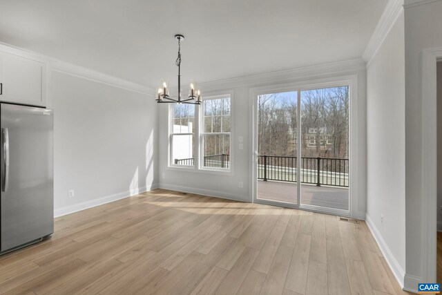 unfurnished dining area with light wood finished floors, crown molding, a chandelier, and baseboards