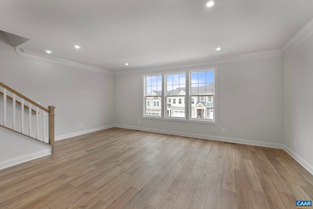 unfurnished living room with stairway, crown molding, baseboards, light wood-type flooring, and recessed lighting