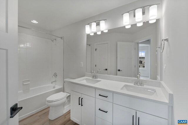 full bath featuring wood finished floors, toilet, double vanity, bathtub / shower combination, and recessed lighting
