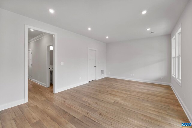 spare room featuring light wood finished floors, baseboards, and recessed lighting