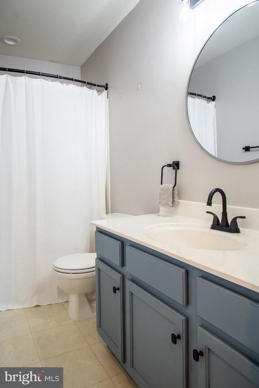 bathroom with vanity, toilet, and tile patterned floors
