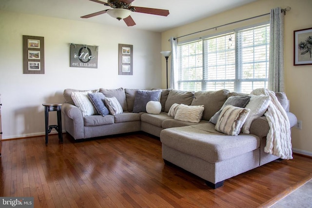 living room with dark wood-style floors, ceiling fan, and baseboards