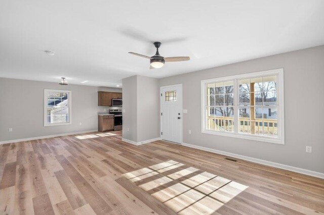 1028 D St, Waynesboro, VA 22980 - unfurnished living room with healthy amount of natural light, baseboards, light wood finished floors, and a ceiling fan