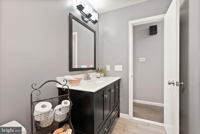  - bathroom with wood tiled floors, vanity, and baseboards