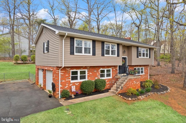  - bi-level home featuring brick siding, a garage, driveway, and a chimney