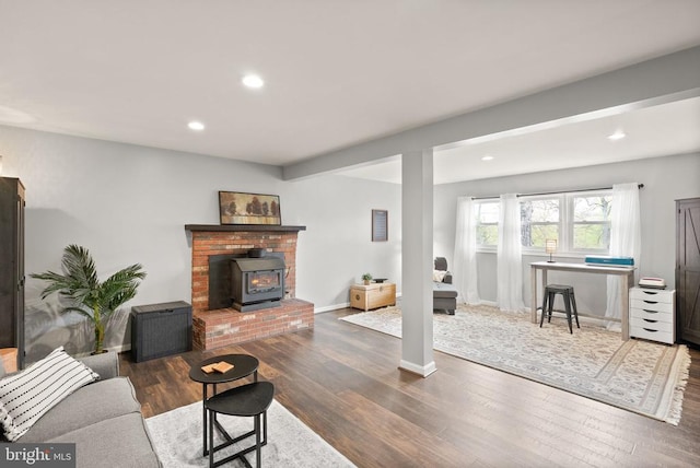  - living area featuring dark wood-style floors, recessed lighting, and a wood stove