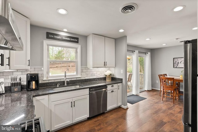  - kitchen featuring dishwasher, a sink, exhaust hood, tasteful backsplash, and recessed lighting