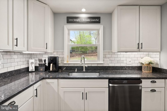  - kitchen featuring stainless steel dishwasher, a sink, and white cabinets