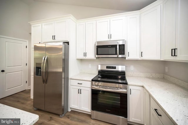 3149 Lewiston Rd, Bumpass, VA 23024 - kitchen featuring appliances with stainless steel finishes, wood finished floors, white cabinets, and lofted ceiling