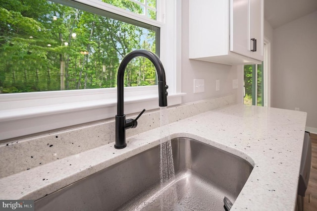 3149 Lewiston Rd, Bumpass, VA 23024 - kitchen view of a sink, white cabinetry, and light stone counters
