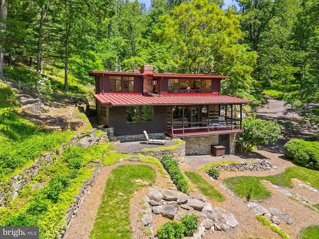 115 Oventop Mountain Ln, Sperryville, VA 22740 - rear view of property featuring a standing seam roof, a chimney, metal roof, a view of trees, and a deck