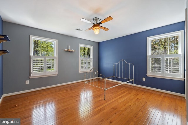  - unfurnished room featuring ceiling fan, hardwood / wood-style floors, and baseboards