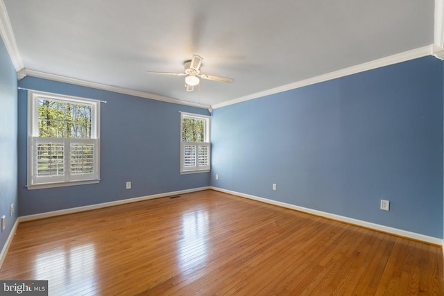  - spare room featuring ornamental molding, ceiling fan, wood finished floors, and baseboards