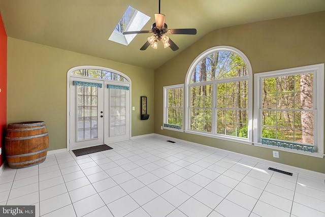  - foyer with french doors, vaulted ceiling, ceiling fan, a skylight, and light tile patterned floors