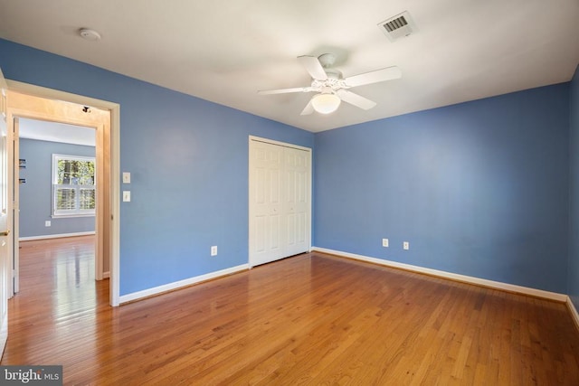  - unfurnished bedroom with baseboards, a closet, wood finished floors, and a ceiling fan