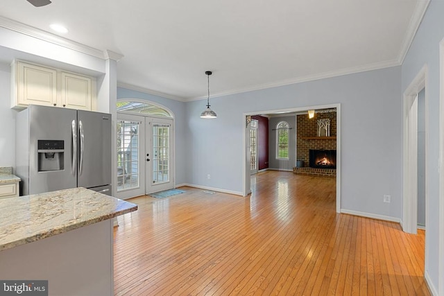  - kitchen featuring stainless steel fridge with ice dispenser, plenty of natural light, open floor plan, light wood-type flooring, and ornamental molding