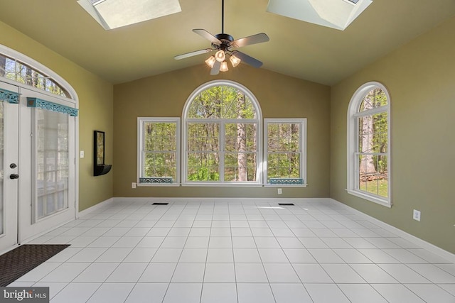  - spare room featuring a skylight, lofted ceiling, ceiling fan, and baseboards