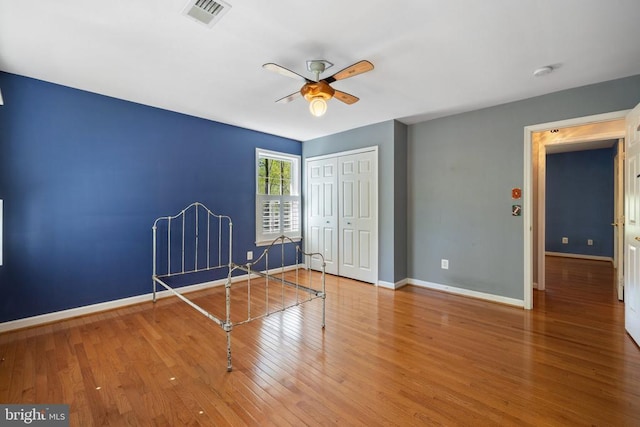  - unfurnished bedroom with baseboards, a closet, wood finished floors, and ceiling fan