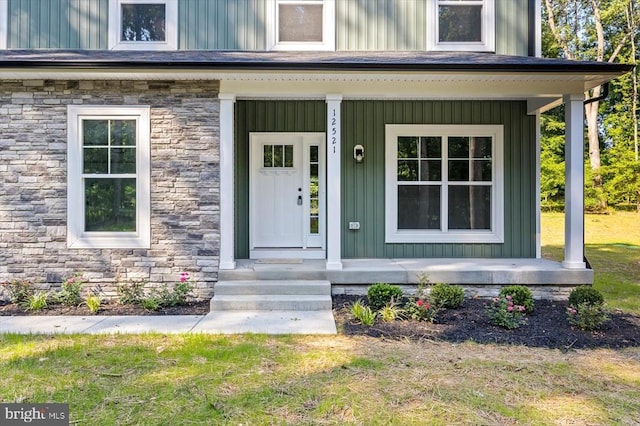12521 Wilderness Park Dr, Spotsylvania, VA 22551 - doorway to property with a porch, stone siding, and board and batten siding