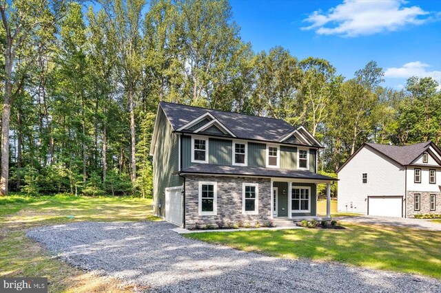 12521 Wilderness Park Dr, Spotsylvania, VA 22551 - view of front of house featuring a garage, gravel driveway, stone siding, and a front lawn