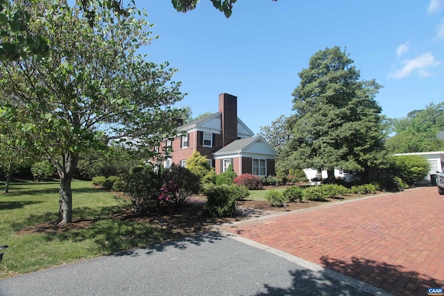 view of front facade with a chimney and a front yard