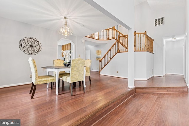 4209 Oakhill Rd, Fredericksburg, VA 22408 - dining space with stairway, wood finished floors, a chandelier, and a towering ceiling