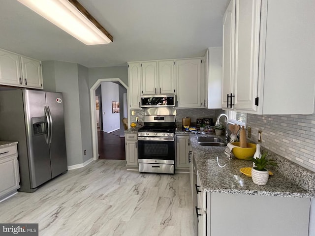 4209 Oakhill Rd, Fredericksburg, VA 22408 - kitchen featuring stainless steel appliances, arched walkways, tasteful backsplash, stone counters, and light marble finish floors